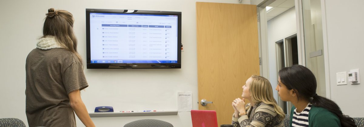  Three students looking at a presentation on the screen.